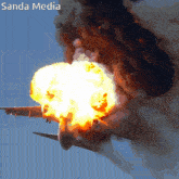 a picture of a plane on fire with the words sanda media written below it