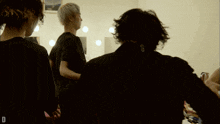 a man in a black shirt is standing in front of a mirror
