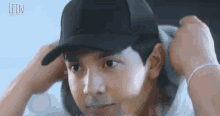 a close up of a man wearing a baseball cap and a bracelet .