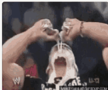 a man is drinking from a glass with his mouth open .