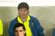a group of soccer players are standing next to each other . one of the players is wearing a yellow shirt .