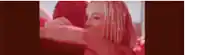 a man and a woman are kissing in a red room .