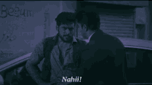 a man in a suit talks to another man in front of a sign that says " begum "