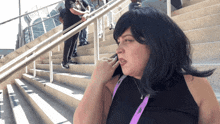 a woman talking on a cell phone with a lanyard around her neck that says ' a ' on it