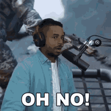 a man wearing headphones is sitting in front of a microphone and says oh no !