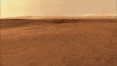 a person 's feet are visible as they walk through the sand