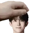 a hand is touching a man 's head with a white background .