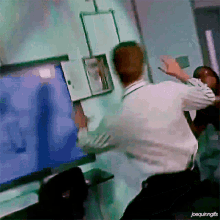 a man in a white shirt is standing in front of a computer screen with the caption joequinngifs
