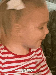 a little girl in a striped shirt says sorry