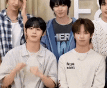 a group of young men are posing for a picture and one of them is wearing a shirt that says her .