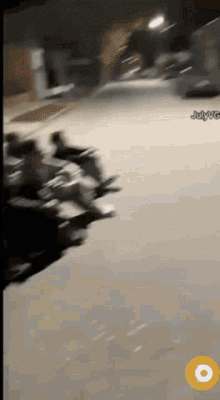 a blurred image of people riding motorcycles on a street with julywg written on the bottom