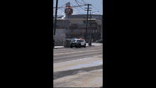 a group of people are walking down a street near a red traffic light
