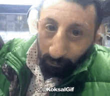 a man with a beard is wearing a green jacket and has the hashtag @koksalgif on the bottom right