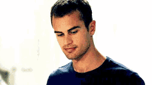 a close up of a man 's face wearing a blue shirt and looking at the camera .