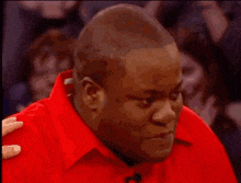 a man in a red shirt is standing in front of a sign that says 23 on it