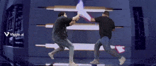 two men are fighting with lightsabers in front of a sign that says viggle.ai