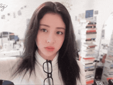 a woman wearing glasses and a white sweater with the letter g on the bottom