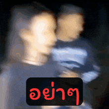 a blurry picture of a man and woman with a sign that says ' a ' in red letters