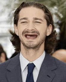 a man in a suit and tie with his mouth open .