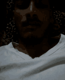 a man with a beard is wearing sunglasses and a white shirt