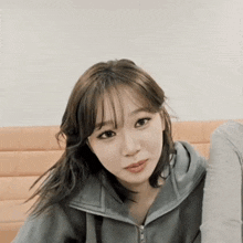 a close up of a woman wearing a grey sweatshirt