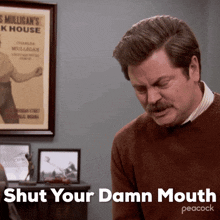 a man says shut your damn mouth in front of a poster