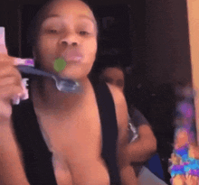 a woman is brushing her teeth with a toothbrush in her mouth