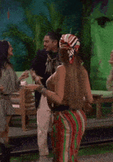 a woman wearing glasses and a scarf is dancing with other women