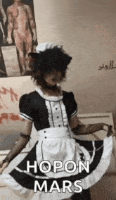 a person in a maid costume is dancing in front of a wall .