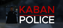 a man in a police uniform is standing in front of a kaban police sign
