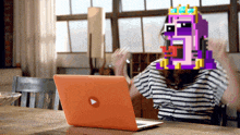 a woman in a striped shirt is sitting in front of an orange laptop with a play button on the screen