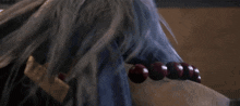 a close up of a person wearing a necklace with red beads on their wrist .