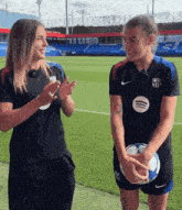 two women standing on a field with one wearing a nike shirt