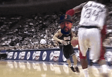 a basketball player with the number 24 on his back is being chased by another player