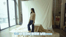 a woman standing in front of a white cloth with korean writing