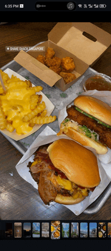 a phone screen shows a tray of food from shake shack in singapore