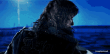 a man with long hair is wearing a jacket that says justice on it