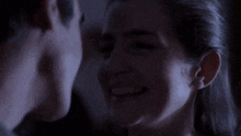 a man and a woman are looking at each other and smiling .