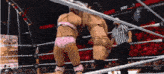two women are wrestling in a ring with a referee and a sign that says nxt in the background