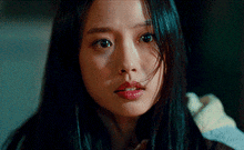 a close up of a woman 's face with long black hair and a nose ring .