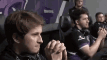 a group of men are sitting in a room playing a video game .