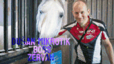 a man standing next to a horse wearing a shirt that says dusan mikrotik boss