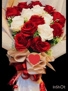 a bouquet of red and white roses with a red heart on top