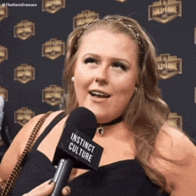 a woman wearing a microphone that says instinct culture