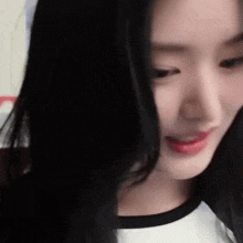 a close up of a woman with long black hair looking at the camera .