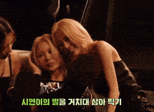 three women are sitting next to each other in a dark room with foreign writing on the bottom
