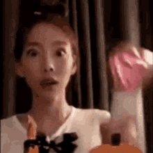 a close up of a woman holding a bottle of perfume in her hand .