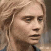 a close up of a woman 's face with netflix written on the bottom right
