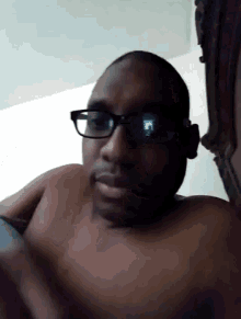 a shirtless man wearing glasses and headphones is making a funny face