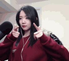 a girl wearing a red sweatshirt that says ' supreme ' on it giving a peace sign